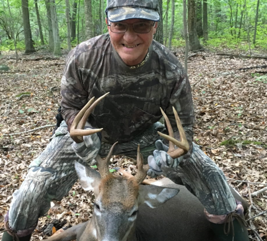 Hunter smiling with his prize buck